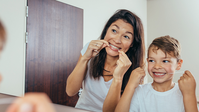 Parent flossing with child Grandville MI pediatric dentists